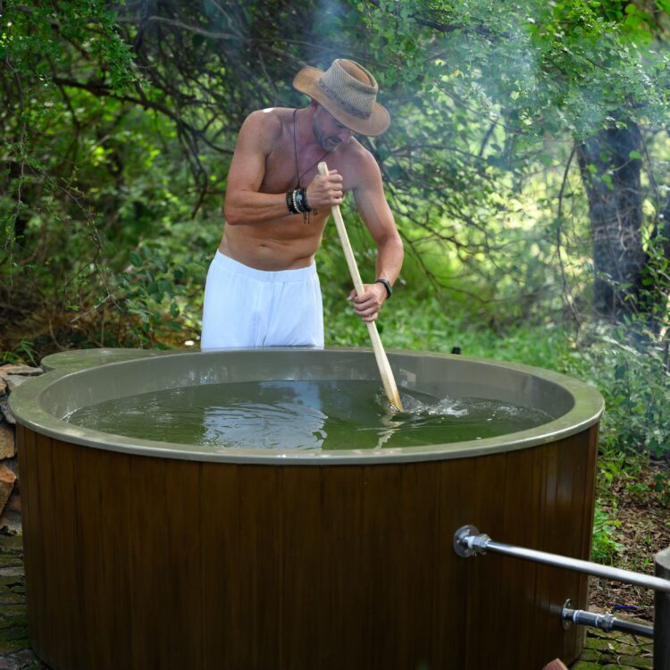Man stirring water with Wooden Paddle